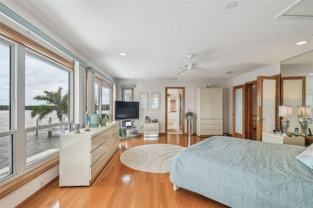 bedroom featuring recessed lighting, light wood-style flooring, baseboards, and ensuite bathroom