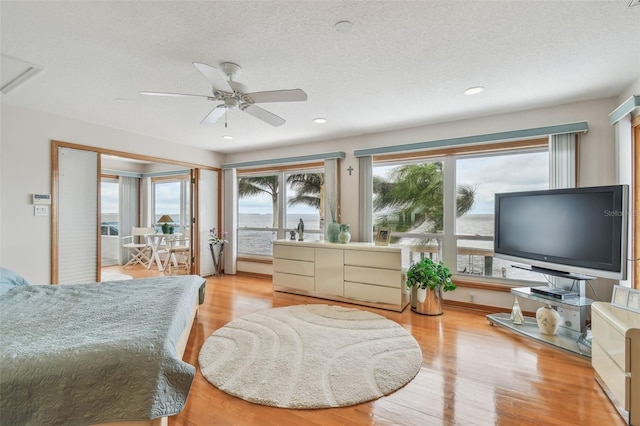 bedroom with light wood finished floors, a textured ceiling, and recessed lighting