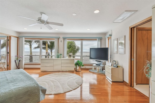 bedroom with recessed lighting, baseboards, light wood-style flooring, and a textured ceiling