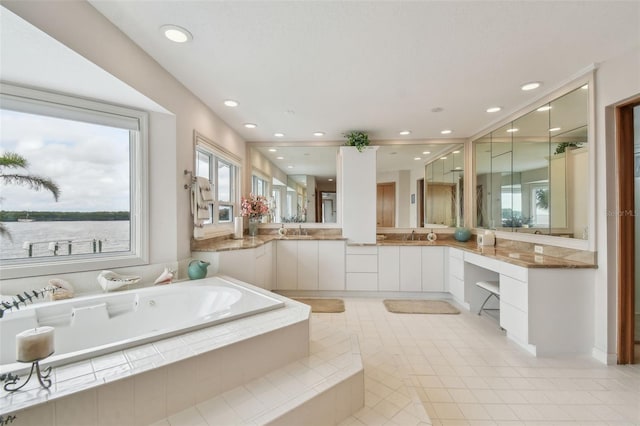 full bathroom with tile patterned flooring, vanity, a bath, and recessed lighting