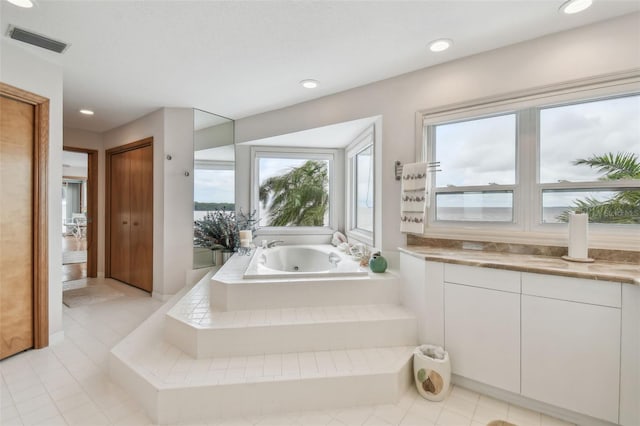 bathroom with recessed lighting, tile patterned flooring, visible vents, and a jetted tub