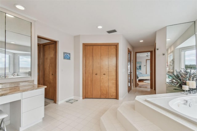 bathroom with baseboards, visible vents, ensuite bath, vanity, and a bath