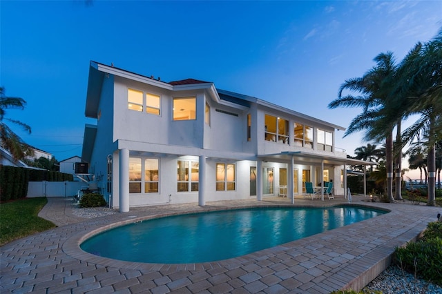 back of property with a fenced in pool, a patio, stucco siding, a gate, and fence