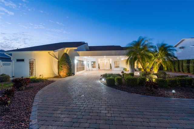 view of front of home featuring decorative driveway and stucco siding