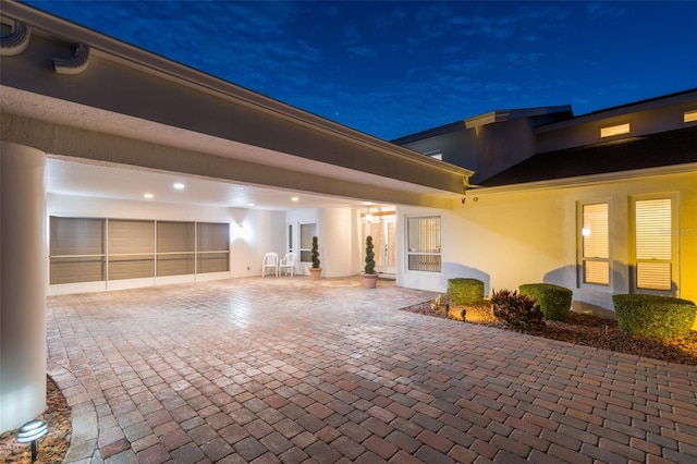 exterior space with a garage, a patio area, and stucco siding