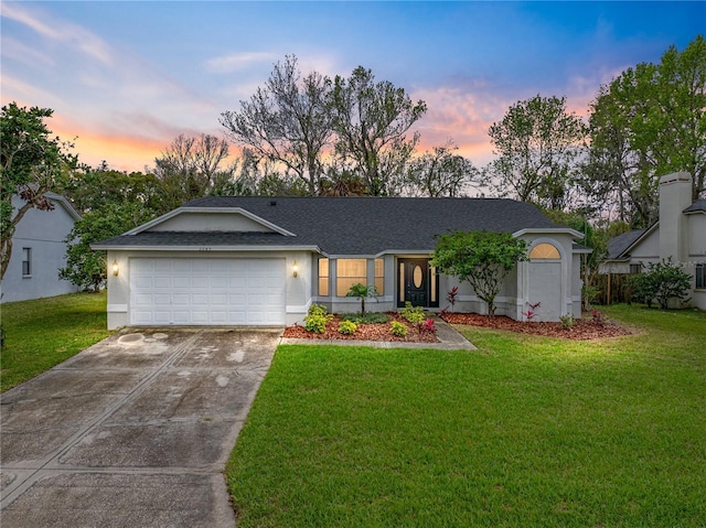 view of front of home featuring a garage, stucco siding, driveway, and a lawn