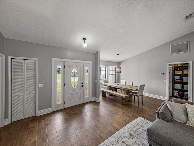 foyer entrance with dark wood-style floors, lofted ceiling, visible vents, and baseboards