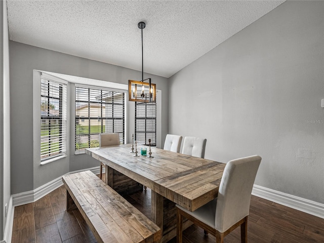 dining room with a notable chandelier, dark wood finished floors, a textured ceiling, and baseboards