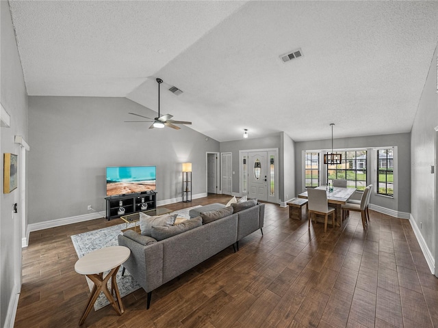 living area featuring vaulted ceiling, visible vents, and dark wood finished floors