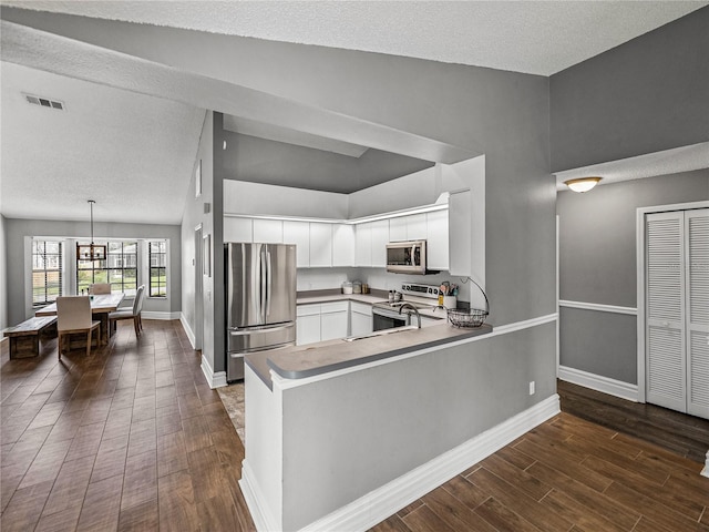 kitchen with white cabinets, visible vents, stainless steel appliances, and dark wood-type flooring