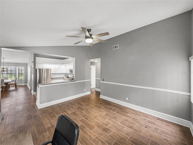 unfurnished living room with wood finish floors, visible vents, vaulted ceiling, and ceiling fan