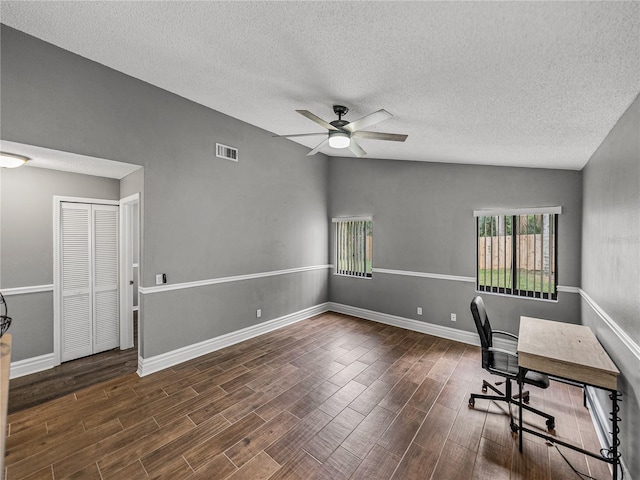 unfurnished office with visible vents, a ceiling fan, vaulted ceiling, and wood finished floors