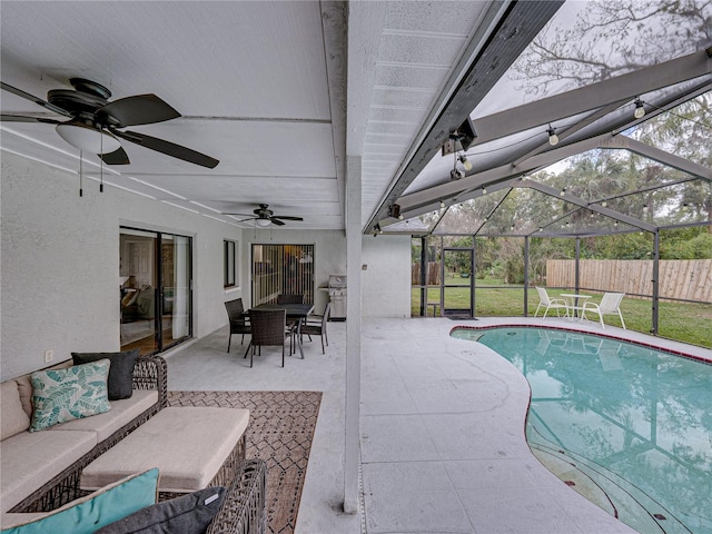 view of swimming pool with a fenced in pool, a ceiling fan, glass enclosure, fence, and a patio area