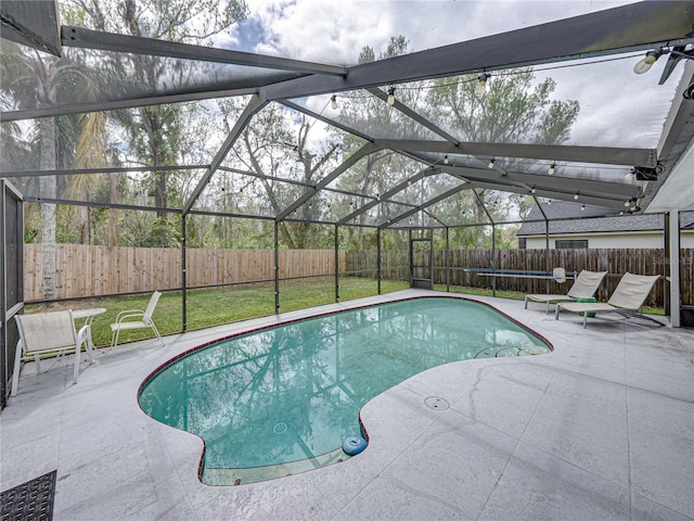 view of pool featuring glass enclosure, a fenced backyard, a fenced in pool, and a patio