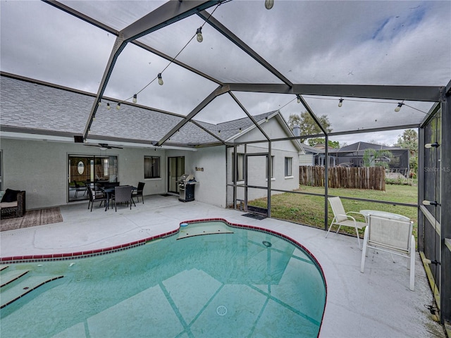 outdoor pool with a patio area, a lanai, and fence