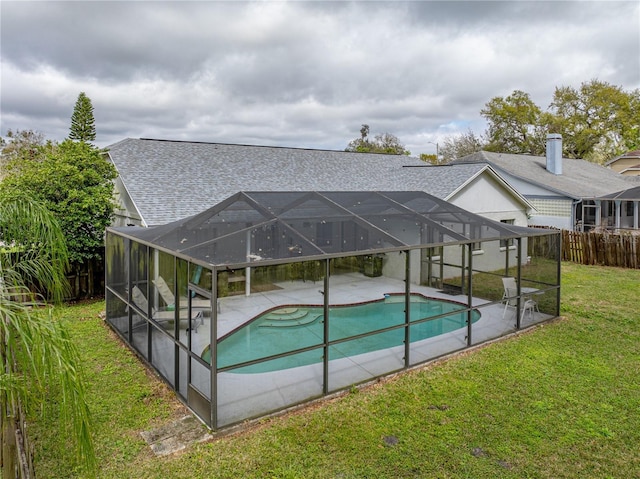 pool with a patio, a lawn, fence, and a lanai