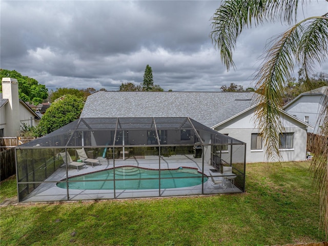 pool featuring a patio area, glass enclosure, and a lawn