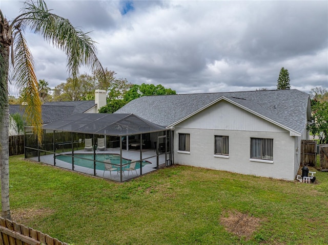 back of property featuring a chimney, a fenced backyard, a lawn, and a lanai