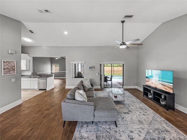 living area featuring lofted ceiling, ceiling fan, wood finished floors, and visible vents