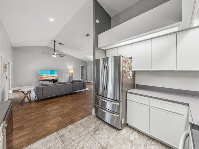 kitchen featuring a ceiling fan, lofted ceiling, freestanding refrigerator, light wood-style floors, and white cabinetry