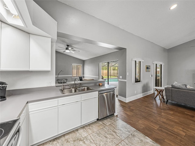 kitchen featuring lofted ceiling, stove, open floor plan, a sink, and stainless steel dishwasher