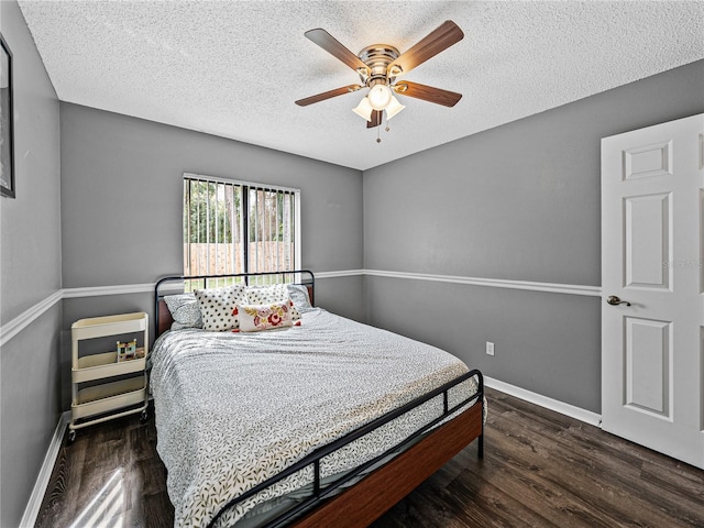 bedroom with a textured ceiling, ceiling fan, wood finished floors, and baseboards