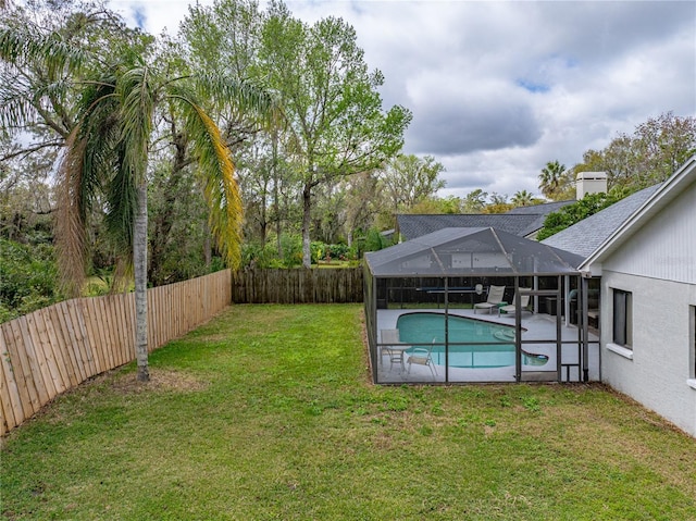 view of yard with glass enclosure, a patio area, a fenced backyard, and a fenced in pool