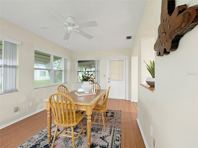 dining area featuring light wood-style floors, baseboards, visible vents, and ceiling fan