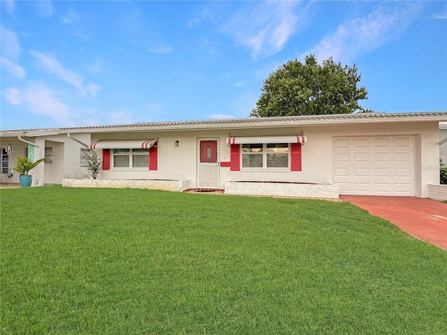 single story home with a garage, driveway, a front yard, and stucco siding