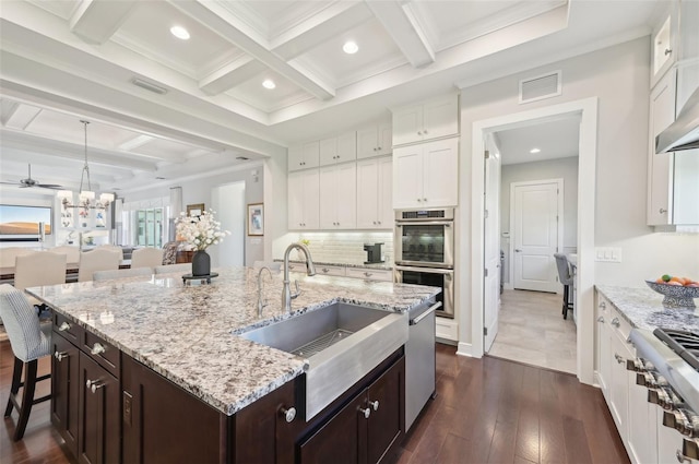 kitchen featuring appliances with stainless steel finishes, white cabinets, visible vents, and a sink