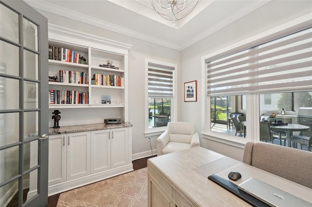 office space featuring baseboards, light wood-style flooring, a chandelier, and crown molding