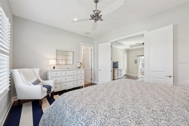 bedroom with a ceiling fan, a raised ceiling, and baseboards