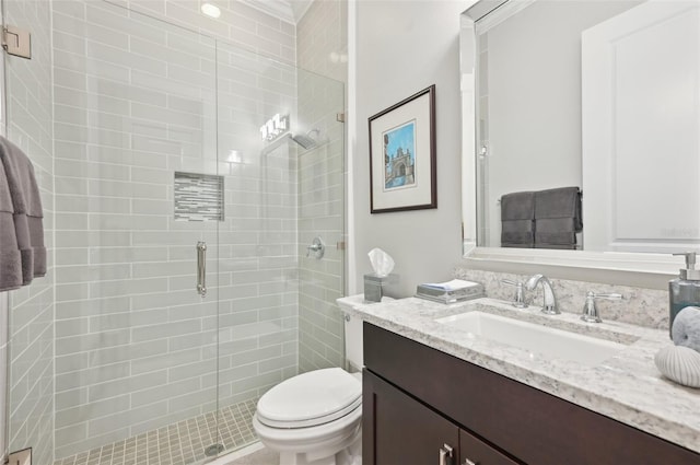 bathroom featuring toilet, a stall shower, and vanity