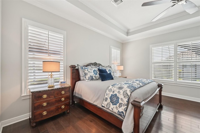 bedroom featuring baseboards, visible vents, dark wood finished floors, and a raised ceiling