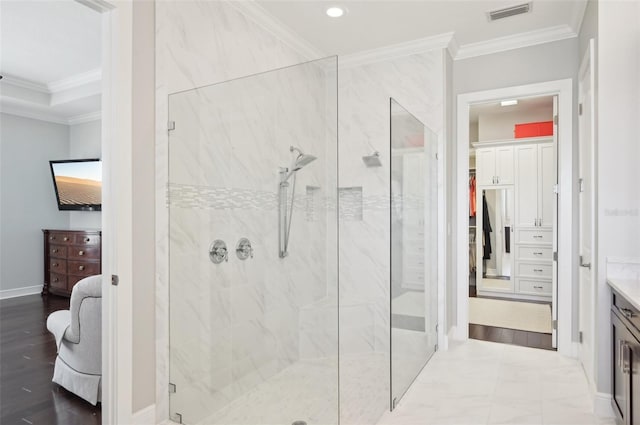 bathroom featuring a marble finish shower, baseboards, visible vents, ornamental molding, and vanity