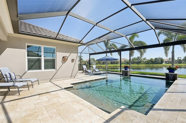 outdoor pool with glass enclosure, a patio area, and a water view