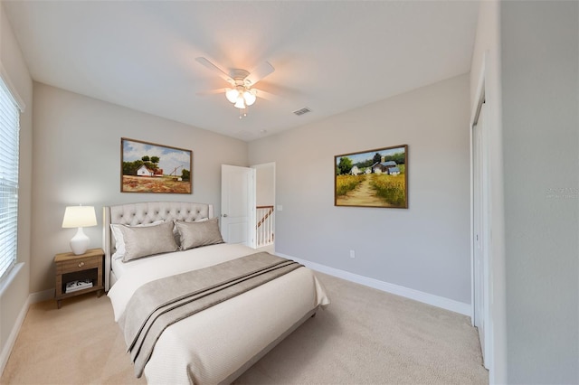 bedroom featuring baseboards, visible vents, and light colored carpet