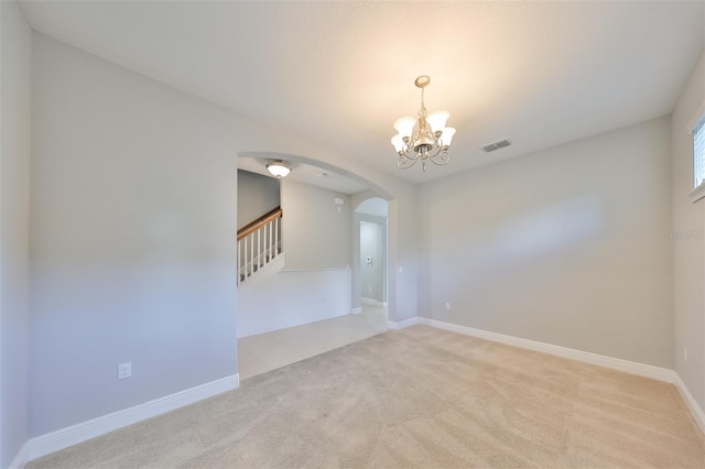 unfurnished room featuring arched walkways, visible vents, an inviting chandelier, light carpet, and stairs