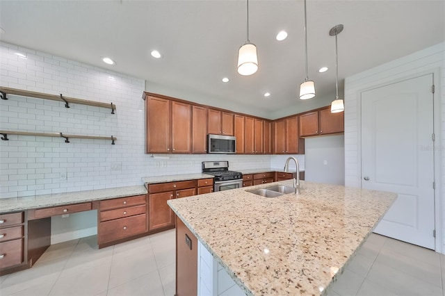 kitchen with light stone counters, stainless steel appliances, hanging light fixtures, a sink, and an island with sink