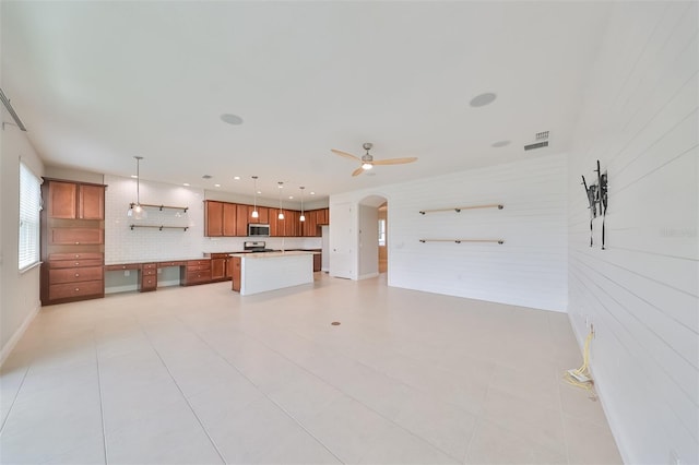 unfurnished living room with arched walkways, ceiling fan, light tile patterned flooring, recessed lighting, and visible vents