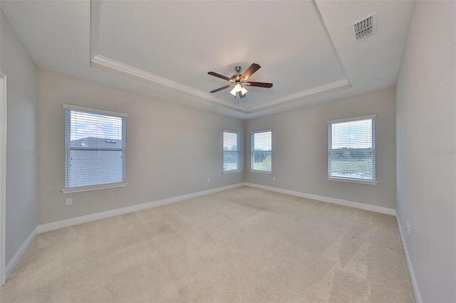 unfurnished room featuring light colored carpet, a raised ceiling, visible vents, and baseboards