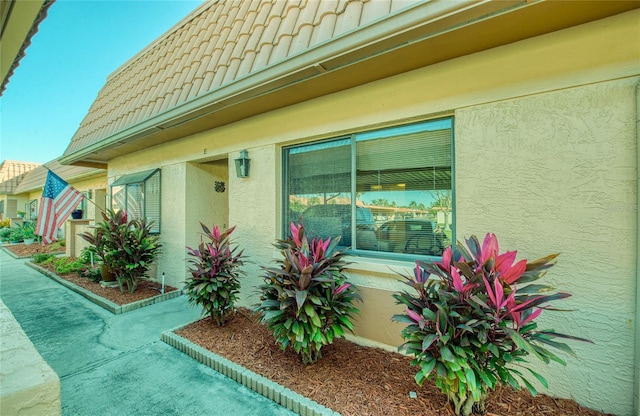 view of home's exterior featuring a tile roof and stucco siding