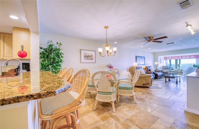 dining space with ceiling fan with notable chandelier, recessed lighting, visible vents, and stone tile floors