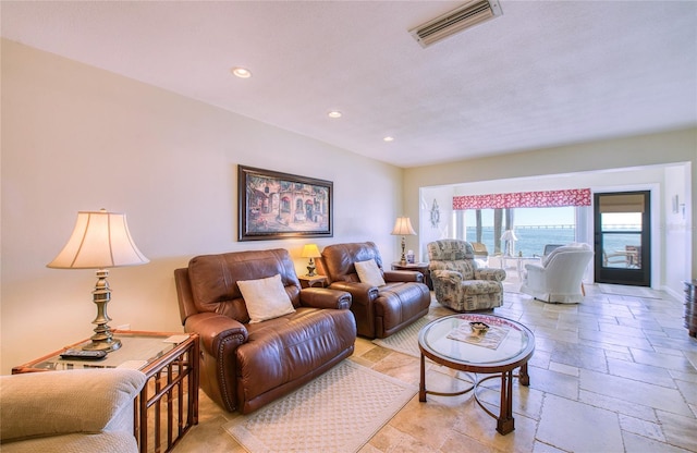 living area featuring stone tile flooring, visible vents, and recessed lighting