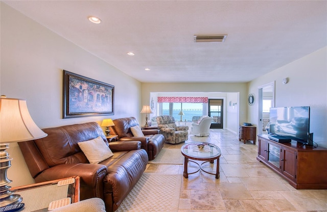 living area featuring stone tile flooring, visible vents, and recessed lighting