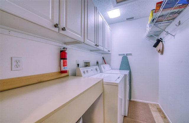 clothes washing area featuring a textured ceiling, visible vents, baseboards, cabinet space, and washer and clothes dryer