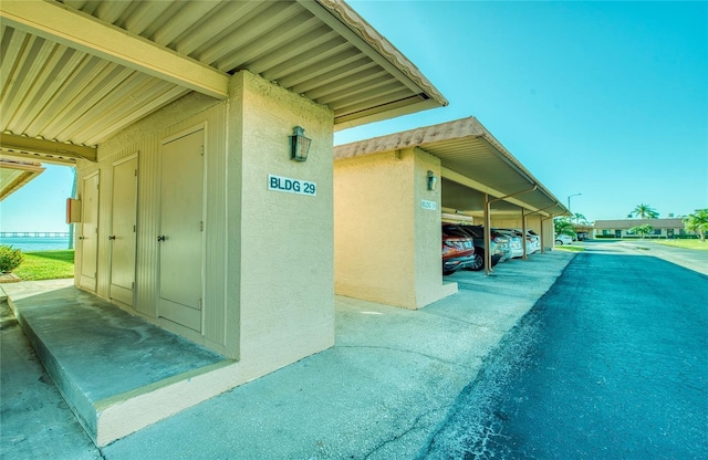 view of side of property with covered parking and stucco siding