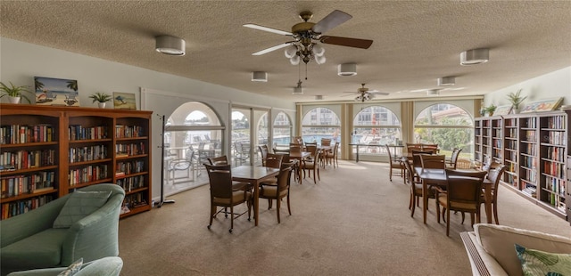 dining area with light carpet, a textured ceiling, and a ceiling fan