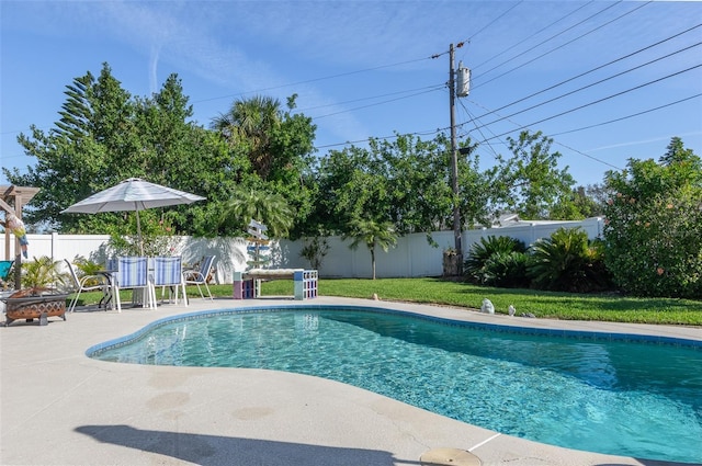 view of swimming pool with a fenced backyard, a lawn, and a fenced in pool