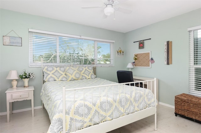 bedroom featuring ceiling fan, baseboards, and wood finished floors